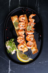 Gourmet Shrimp Skewers on Crispy Bread with Lemon Wedge and Fresh Green