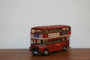 Obraz premium Bucharest Romania 16 November 2025.A vintage painting of a classic red English bus displayed on a wooden table. The artwork features the iconic double-decker bus in retro tones.