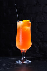 Vibrant Orange Cocktail With Ice And Orange Peel Garnish In A Tall