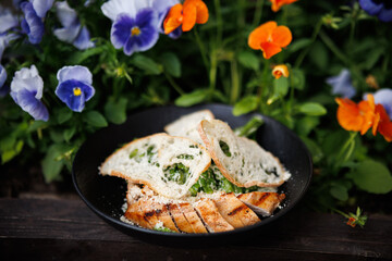 A Picnic Dish in the Garden with Yogurt, Roasted Chicken. brightly blooming Flowers
