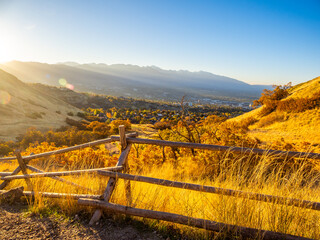 Golden sunrise light over Ensign Peak slopes overlooking Salt Lake City and distant mountains