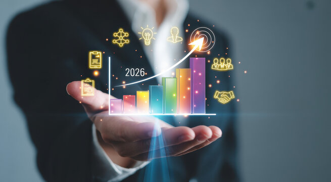 Businessman hand holding a glowing 2026 growth bar chart with upward arrow and business strategy icons for future success
