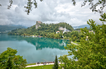 Lake Bled, Slovenia – July 22, 2025: Panoramic view of Bled Castle and St. Martin’s Church overlooking the turquoise lake and island from a nearby terrace.
