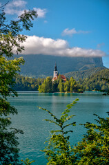 Naklejka premium Lake Bled, Slovenia – July 22, 2025: Scenic views of Bled Island and its iconic Church of the Assumption surrounded by the Julian Alps and crystal waters. 