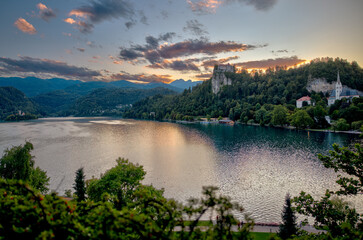 Lake Bled, Slovenia – July 22, 2025: Panoramic view of Bled Castle and St. Martin’s Church overlooking the turquoise lake and island from across the lake.
