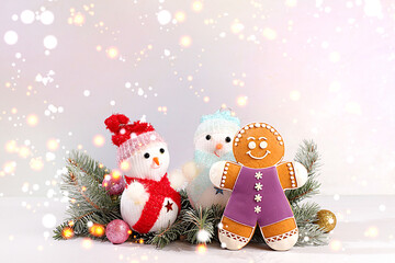 Happy New Year. Festive winter greeting card, gingerbread, snowmen and Christmas ornaments on snowy fir branches, Christmas Eve concept, New Year's background with lights and decorations
