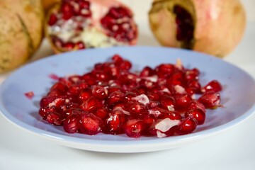 Pomegranate arils on plate with fresh fruit