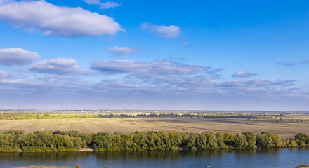 Beautiful blue sky with a few clouds and a river in the background
