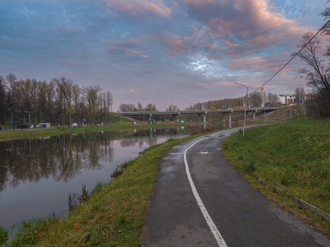 Road runs alongside a river, with a bridge in the distance