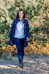 Female portrait. Beautiful young girl with long dark hair on a sunny autumn day outdoors. Vertical photo. High quality photo