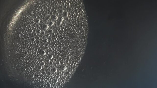 Water droplets evaporating in heated pan under high temperature timelapse