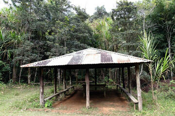 open-air, rustic wooden pavilion with a corrugated metal roof