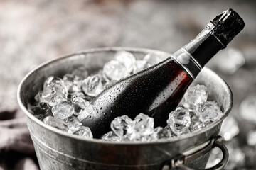 Black Champagne Bottle Chilling in Ice Bucket with Water Droplets Close-Up View