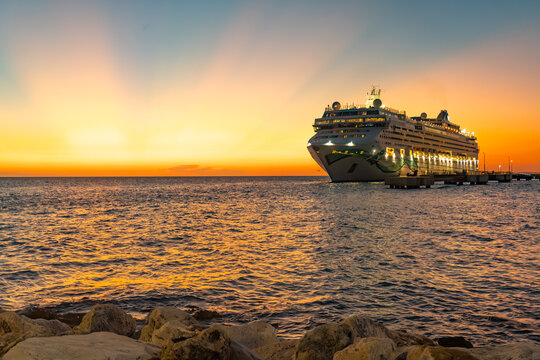 Willemstad, Curacao: Norwegian Jade cruise ship in moored in Cura&ccedil;ao with a stunning sunset. Norwegian Cruise Line (NCL). Mega Cruise Terminal near Renaissance Park.