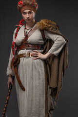 A young Viking woman, a combat heroine in a fantasy Nordic costume with a Scandinavian battle axe...