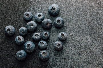 Fresh blueberries scattered on a dark surface ready for a healthy snack or recipe
