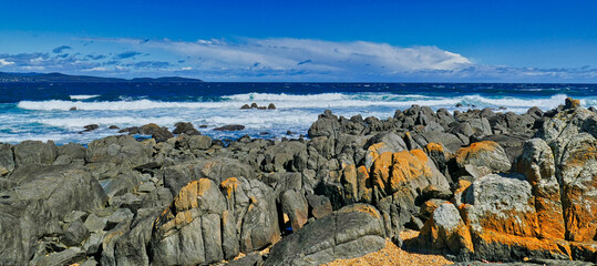 Panorama of a rugged rocky coast and breaking waves on a stormy day. Low Head, George Town, in the Launceston region of northern Tasmania, Australia.  

