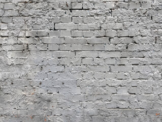 Close-up of an old brick wall painted in light gray, showing rough texture, uneven surface, and visible cracks for a rustic, weathered look.