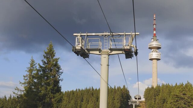Bottom view of mountain lift and a tower Snezhanka on one of the Rhodope mountains in cloudy weather
