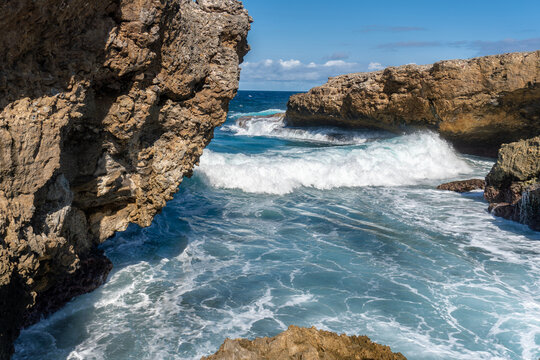 Shete Boka National Park in Curacao. Waves pound against coral rock formations and saltwater splashes high into the air. Cliff-like sea coves.