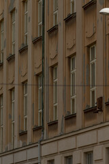 beige residential elevation with repeating windows and delicate cornices, vertical rhythm and soft shadows