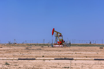 Oil drilling derrick pumps oil from ground on an oil field in Kazakhstan