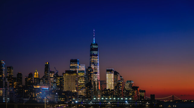 New York City downtown skyline at a dramatic sunset over the Hudson River, USA