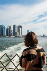 Woman looking back at city from ferry