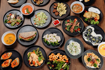 Assorted restaurant dishes on a wooden table, overhead flat lay of a catering menu