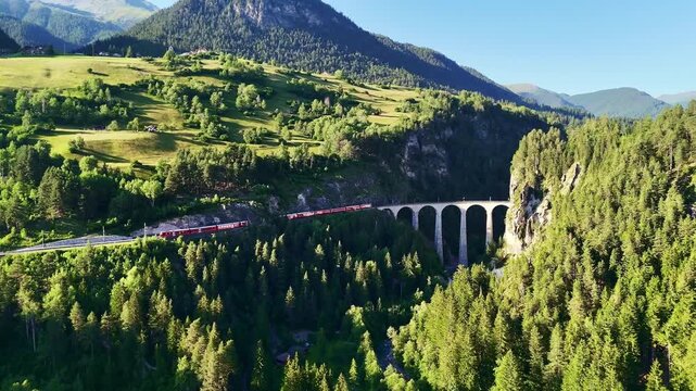 red swiss train on Landwasser viaduct bridge in Swiss Alps. Zermatt to St. Moritz.  scenic railway. Switzerland summer tourism.