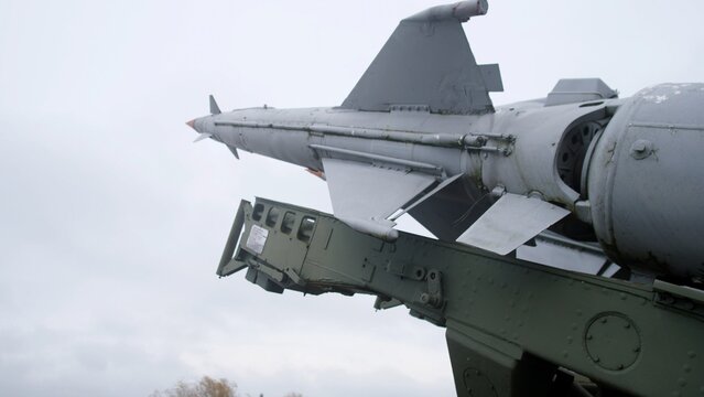 closeup of missile attached to wing pylon, aircraft missile with support structure under cloudy sky