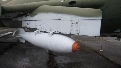 external bomb mounted under fuselage ready for transport, ground loader staging ordnance for cargo mission