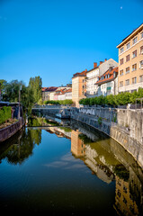 Obraz premium Ljubljana, Slovenia – July 14, 2025: A scenic view of the Ljubljanica River as it winds through the historic center of Ljubljana.