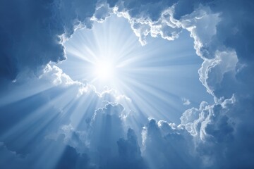 Bright sun rays breaking through a dramatic cloud formation in a serene blue sky