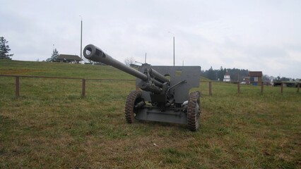 abandoned artillery positioned on open fields forming part of memorial exhibit under subdued sky