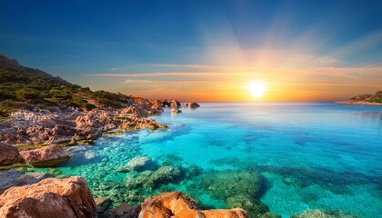 Crystal Clear Turquoise Water Reflecting A Vibrant Sunrise Over Rocky Coastline