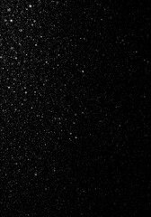 Abstract shot of white snow falling rapidly down onto a dark, pure black background, symbolizing winter weather and cold conditions, frozen, cold, design