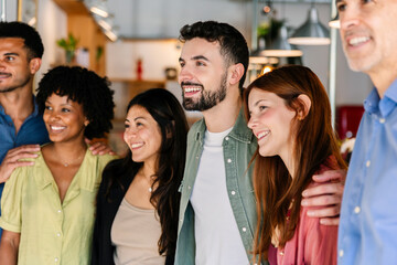 Diverse business team posing together in modern office. Coworkers smiling for group portrait. Unity and teamwork concept.