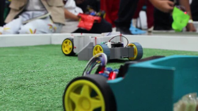 Small robots playing soccer with a ball on a field during a technology and artificial intelligence event at a convention center in Neiva, Huila, Colombia. Concept of technology and innovation 