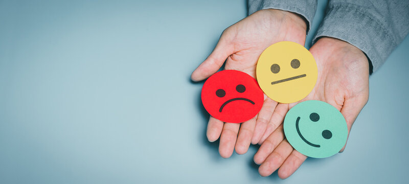 Hands holding multicolor emotion faces, mental condition variation, mood diagnosis awareness, stress evaluation, emotional wellbeing, psychological care guidance, mind balance concept