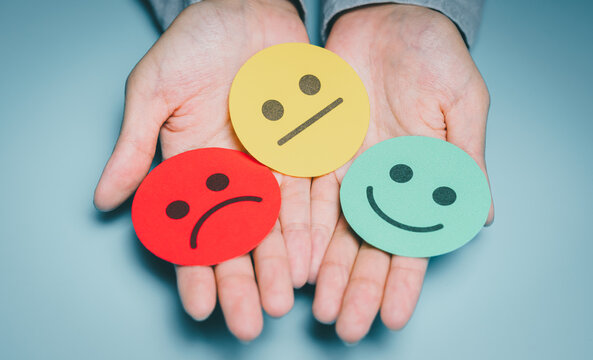 Hands presenting three mood faces, emotional state variety, anxiety awareness, stress level check, mental health reflection, psychology support guidance, wellbeing improvement concept