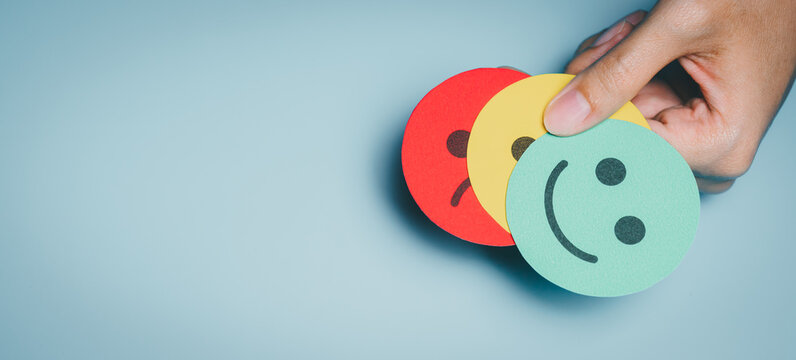 Hand holding stacked emotion faces, mood change awareness, stress and anxiety reflection, emotional wellbeing monitoring, psychological insight, self check guidance, emotion concept