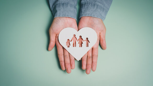 Hands holding heart cutout with family figures, emotional bonding awareness, mental wellbeing support, family connection insight, love stability guidance, protective care responsibility concept