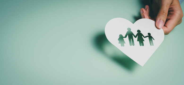Hand holding heart family cutout, emotional bonding awareness, relationship care, mental wellbeing support, unity stability insight, protective family connection concept