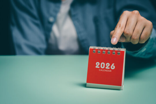 Hand pointing at red 2026 calendar, time management awareness, productivity focus, mental clarity planning, stress reduction insight, organized scheduling preparation concept