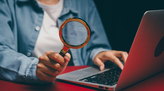 Magnifying glass and laptop usage, verification awareness, research accuracy insight, analytical inspection mindset, careful review responsibility, digital investigation concept