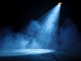 Single blue spotlight beam cuts through smoke on dark concrete floor.