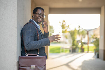 African american businessman talking on mobile phone smiling outdoors