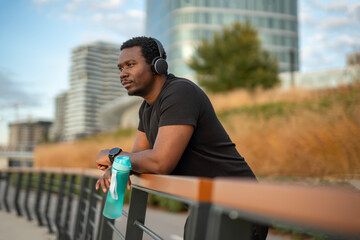 Young black man relaxing with music outdoors