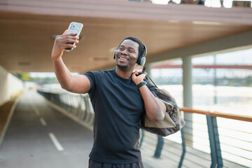 Happy young black man taking selfie outdoors